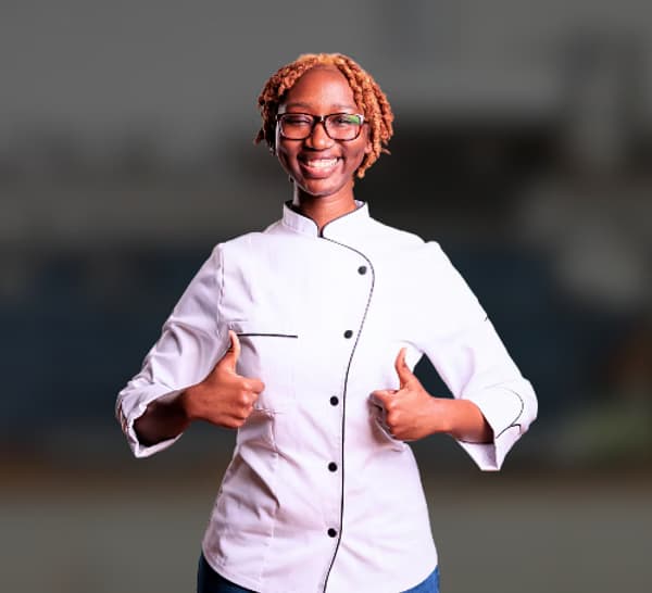 Smiling female chef giving thumbs up